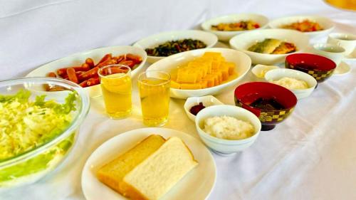 a table with bowls of food and glasses of beer at Saga Idaimae Green Hotel in Saga