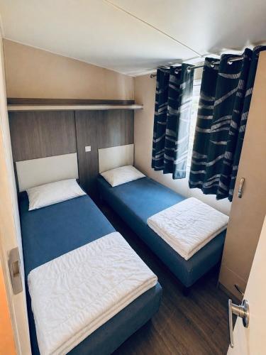 two beds in a small room with at Chalet am Wattenmeer Holland in Lauwersoog