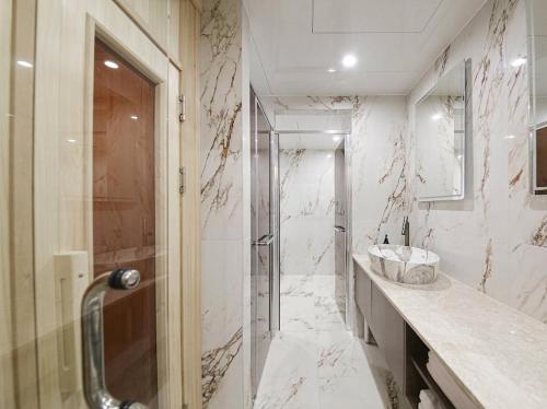 a bathroom with a shower and a sink at 제니스 호텔 in Jecheon