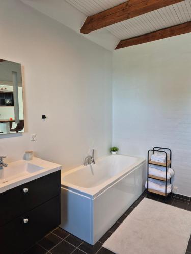 a bathroom with a tub and two sinks and a bath tub at Olsson B&B in Randers