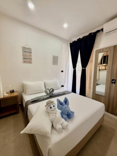 a bedroom with two beds with stuffed animals on them at Hero House in Pooc