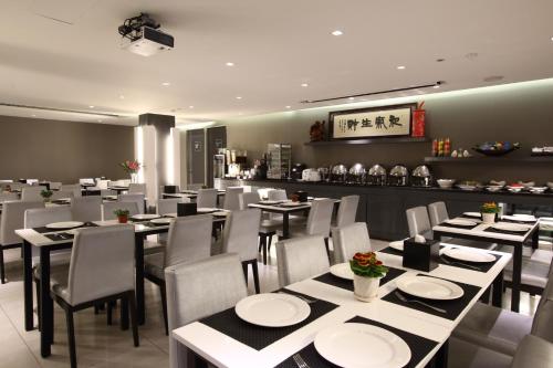un comedor con mesas y sillas en un restaurante en Long View Hotel en Danshui