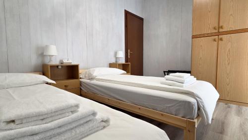 two beds in a room with towels on them at MAGIA - Tra Laghi e Montagne in Gravellona Toce