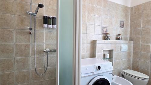 a bathroom with a toilet and a washing machine at MAGIA - Tra Laghi e Montagne in Gravellona Toce