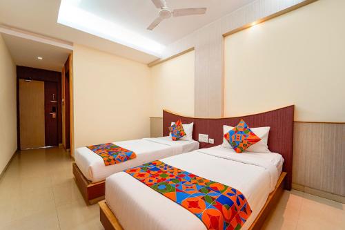 a bedroom with two beds with colorful sheets at FabHotel Grand Gunas in Coimbatore