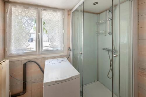 a bathroom with a shower and a washing machine at Gite de Puisaye in Breteau