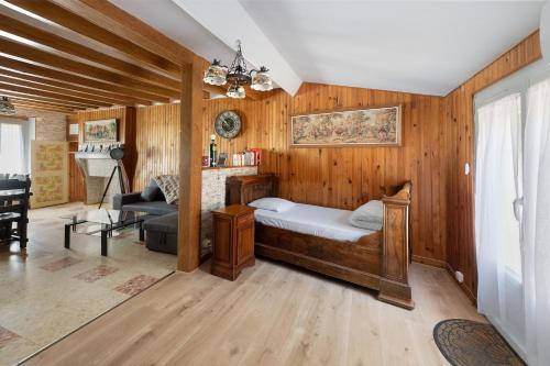 a bedroom with a bed in a room with wooden walls at Gite de Puisaye in Breteau