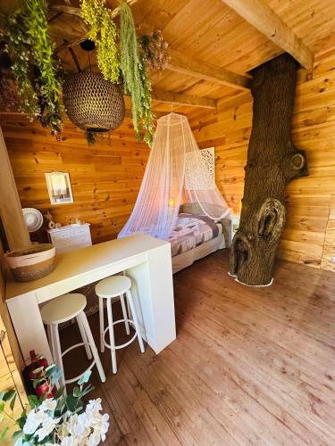 a room with a hammock in a log cabin with a tree at Les Lodges de l'Etang in Roquebrune-sur-Argens
