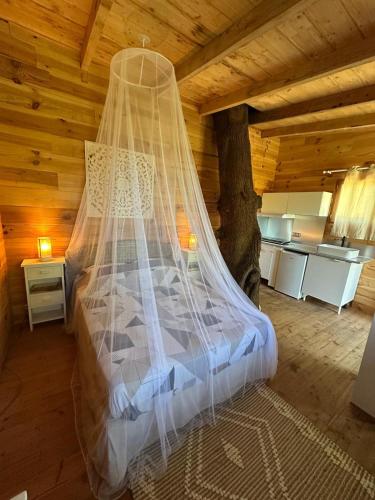 a bedroom with a bed with a mosquito net at Les Lodges de l'Etang in Roquebrune-sur-Argens