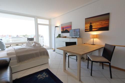 a bedroom with a bed and a desk in a room at Weber19 - Haus Hammerich in Wenningstedt