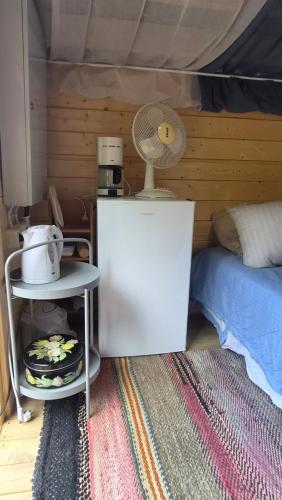 a room with a bed and a table with a fan at Pikku aitta in Heikkilä