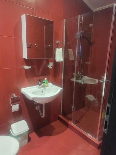 a red bathroom with a sink and a shower at Seaview apt. 3 complex Karia in Kavarna