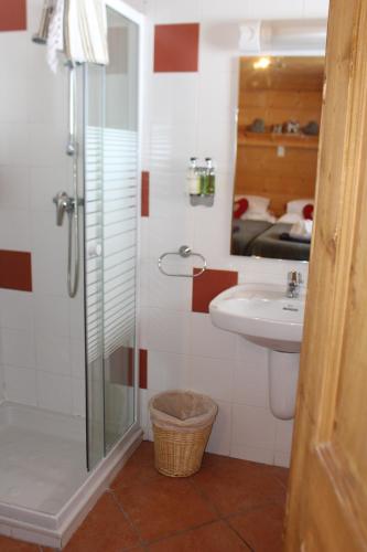 a bathroom with a shower and a sink and a mirror at Chalet Le Plan des Rochers in Morzine