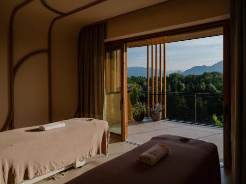 zwei Betten in einem Zimmer mit Blick auf einen Balkon in der Unterkunft Genussdorf Gmachl - Hotel & Spa in Bergheim
