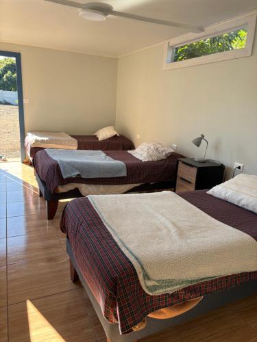 a bedroom with three beds and a lamp on a table at SOL DE LA PALMA in Quillota