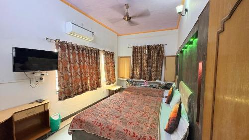 a small bedroom with a bed and a tv at Hotel Taj Plaza, Just a 5-minute walk from the Taj Mahal 600 meters in Agra