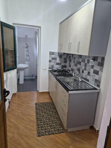 a kitchen with a sink and a stove top oven at Agron S in Vlorë