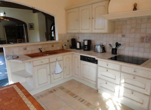 a kitchen with white cabinets and a sink at Gite Du Moulin De Veyriat in Lescheroux