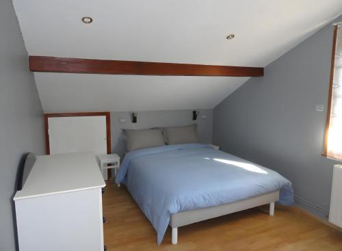 a bedroom with a white bed and a wooden ceiling at Gite Du Moulin De Veyriat in Lescheroux