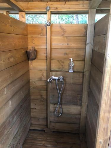 a bathroom with a shower in a wooden wall at Calme et Nature in Saint-Leu
