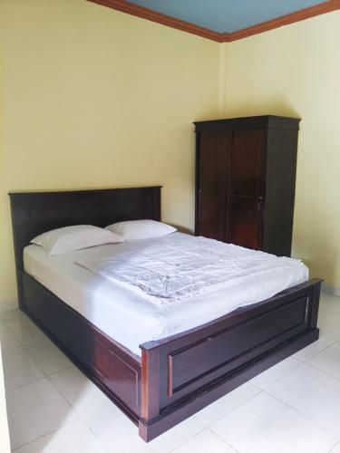 a large bed in a bedroom with a wooden headboard at Nangas Homestayy in Huu