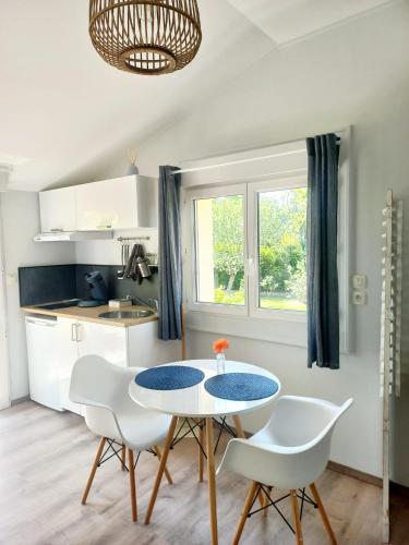 a kitchen with a table and chairs in a room at Studio cosy avec terrasse privée - arrivée autonome in Rouffiac-Tolosan