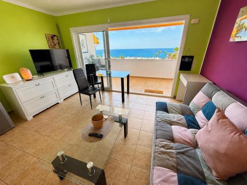 a living room with a couch and a view of the ocean at Top augestattetes Apartment Monte Rojo in Maspalomas