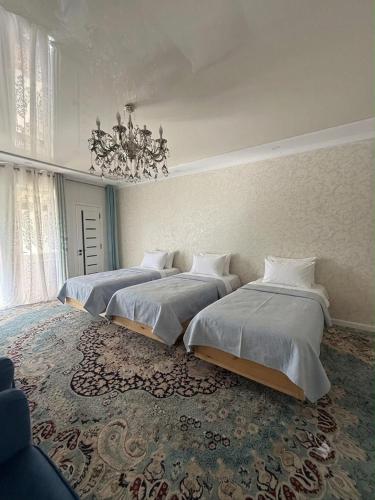 a room with three beds and a chandelier at Kaganat village in Uchar