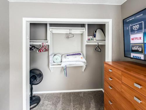 a room with a closet with a dresser and a tv at Town House in Norman