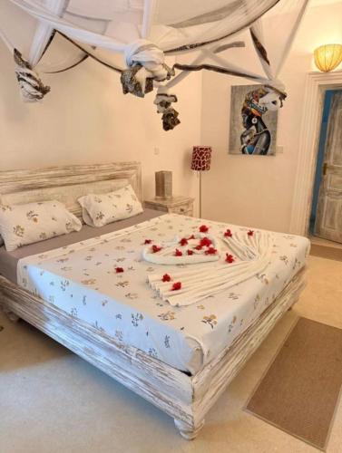 a bedroom with a large bed with roses on it at WHITE Nyumba Malindi - Boutique Villa in Malindi
