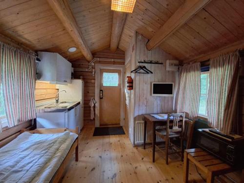 a room with a bed and a table in a cabin at Sandvikengården Stugby in Edane