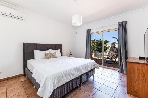 a bedroom with a large bed and a balcony at Villa Sea View Carvoeiro in Carvoeiro