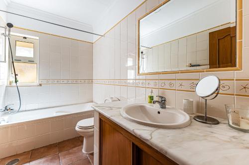 a bathroom with a sink and a toilet and a mirror at Villa Sea View Carvoeiro in Carvoeiro