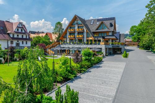 a large house with a garden in front of it at Hotel Litworowy Staw in Białka Tatrzańska