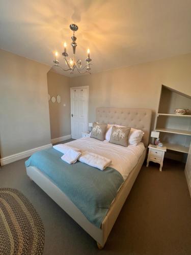 a bedroom with a large bed with a chandelier at Cheerful and spacious 3 bed home in Clitheroe in Clitheroe