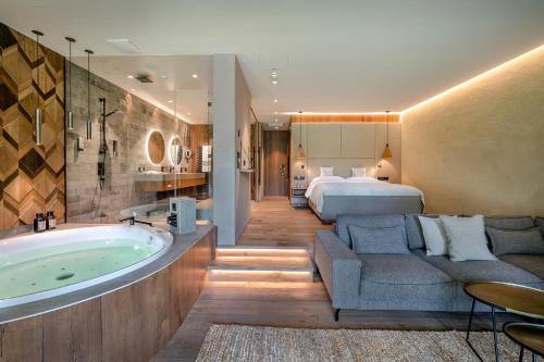 ein Hotelzimmer mit Badewanne und Bett in der Unterkunft Genussdorf Gmachl - Hotel & Spa in Bergheim