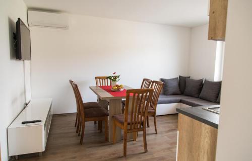 a living room with a table and chairs and a couch at Apartments Ema in Podčetrtek