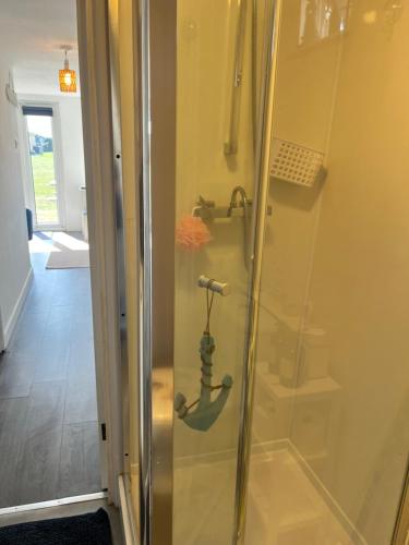 a shower with a glass door in a bathroom at The Lookout in Leysdown-on-Sea