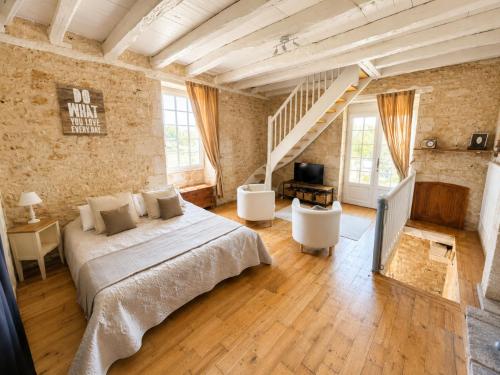 a large bedroom with a bed and a staircase at Domaine de Bagnegrole in Saint-Cyprien