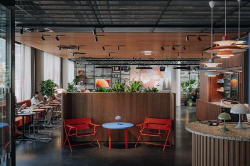 a restaurant with red chairs and tables in a room at URBAN LOFT Cologne in Cologne