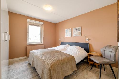 a bedroom with a bed and a chair at Dorpsplein 42 in Callantsoog