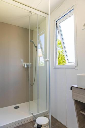 a bathroom with a shower with a toilet and a window at Camping Sud Ardèche 3 étoiles familial piscine chauffée Gorges de l Ardèche Saint Remèze in Saint-Remèze