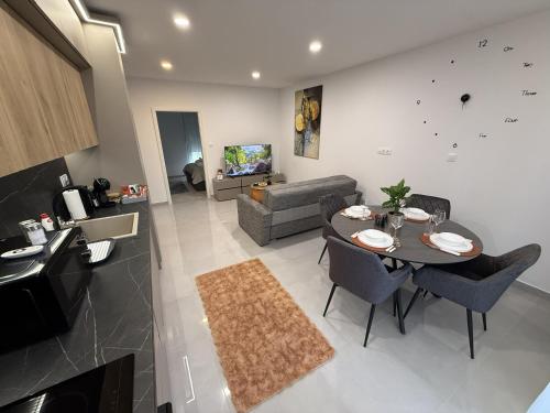 a kitchen and living room with a table and chairs at ViA Lux Apartman in Pécs