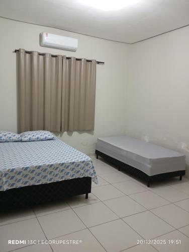 a bedroom with two twin beds and a window at EcoRupestre Hostel & Receptivo in São Raimundo Nonato