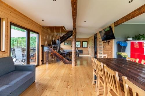 a living room with a large wooden table and chairs at Leśny Wyraj in Borsuki