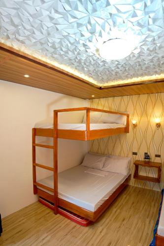 a bunk bed in a room with a ceiling at RAC's Inn Malumpati in Pandan