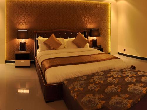 a bedroom with a large bed and two lamps at Nelover Qurtubah-Serviced apartments in Riyadh