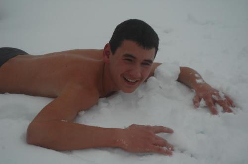 a young man laying in the snow at Majątek Giże Marczak in Olecko