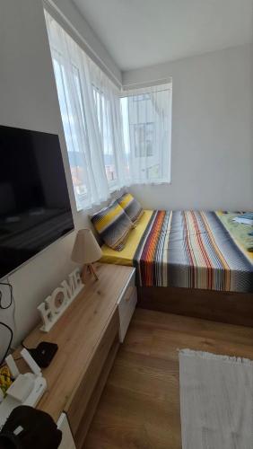 a small bedroom with a bed and a flat screen tv at DIV Apartman in Vrnjci