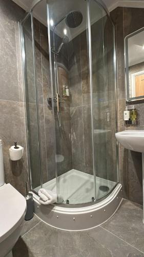 a shower with a glass door in a bathroom at Redstones in Dufton